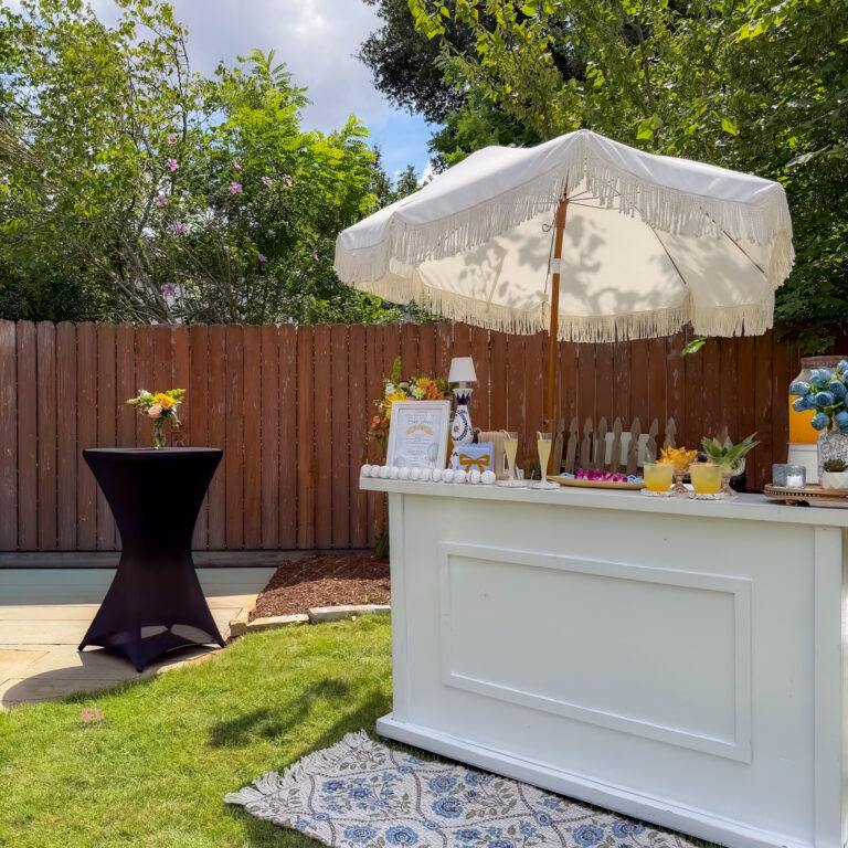 Outdoor white mobile bar setup in Houston with umbrella, cocktail display, and private party styling by I’ll Drink To That!