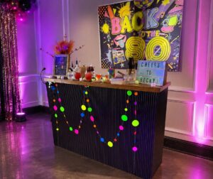 Black mobile bar decorated for a neon 80s-themed birthday party in Houston