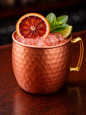 Scarlet Blood Orange Mule | Houston Mobile Bar Signature Cocktail Scarlet Blood Orange Mule cocktail served by a Houston mobile bar in a copper mug with dehydrated blood orange, fresh mint, and lime garnish.