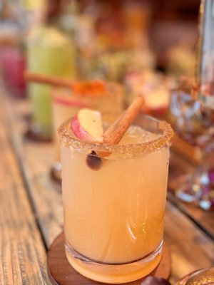 Winter Orchard Elixir Winter Orchard Elixir Margarita with tequila, apple cider, maple syrup, and lime, garnished with apple slices and cinnamon — I’ll Drink To That! mobile bar craft cocktail