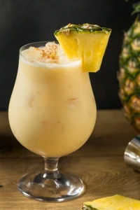 Piña Colada cocktail served frozen with a pineapple wedge and cherry garnish, created by a mobile bartending service for weddings and summer parties.