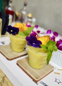 Frozen pineapple coconut mojito mocktail made with a mobile bar frozen drink machine, garnished with mint and lime.