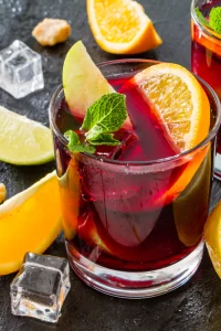 A vibrant glass of red sangria filled with fresh citrus slices and berries, served over ice by I’ll Drink To That! mobile bartending service.