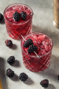 BlackBerry Bourbon Smash cocktail made with fresh blackberries, bourbon, lemon, ginger syrup, and sparkling water, garnished with whole blackberries and a lemon twist from I’ll Drink To That! mobile bar.